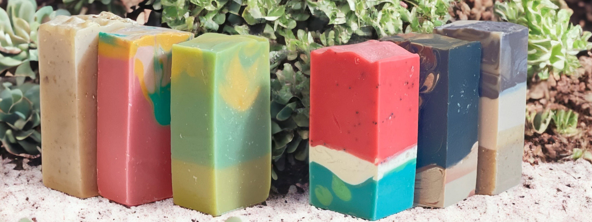 Image showcasing the Pure Indulgence Soap Collection, featuring a variety of artisanal soaps including Unscented Oatmeal Milk and Honey, Island Sunrise, Lemongrass, Watermelon, Treasured Charcoal, and Scented Oatmeal Milk and Honey.